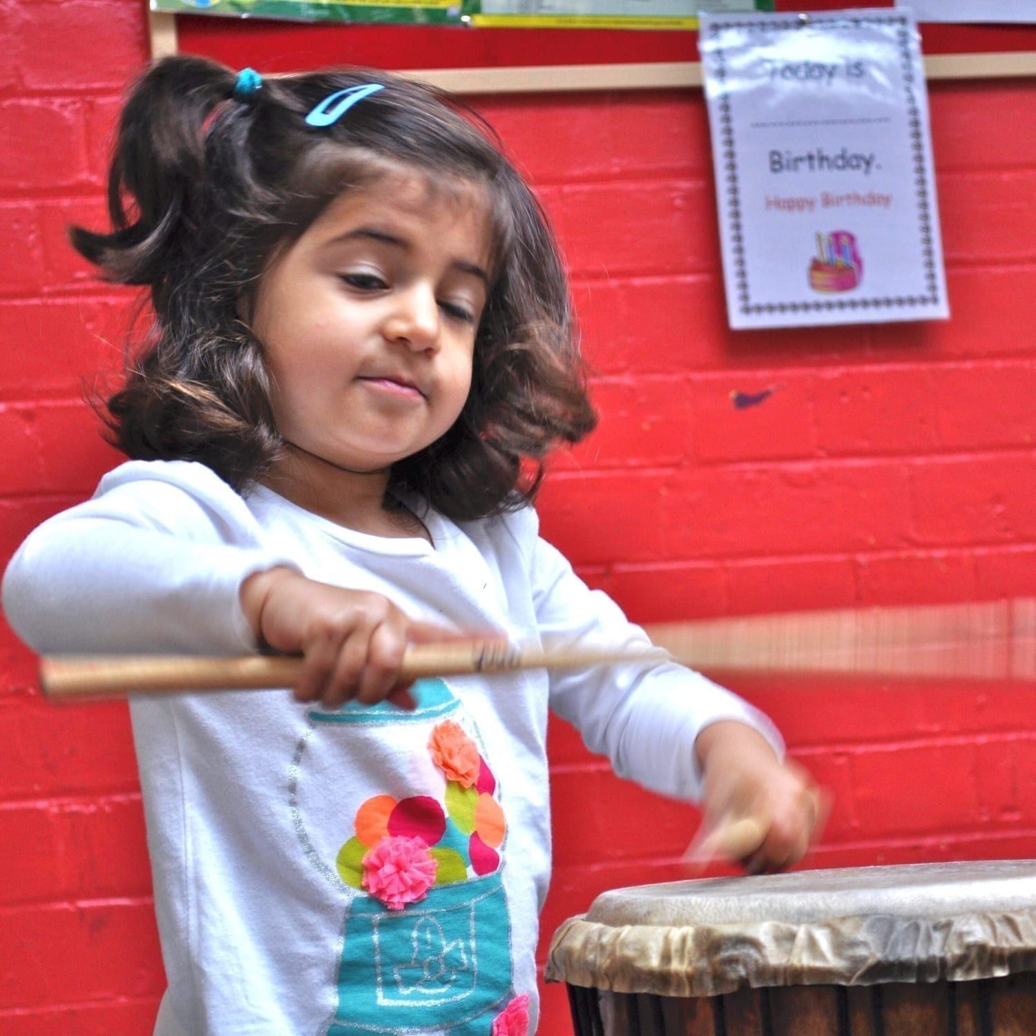 Early years child playing percussion